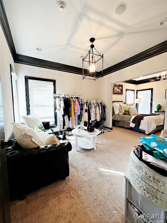 carpeted bedroom featuring a notable chandelier and ornamental molding