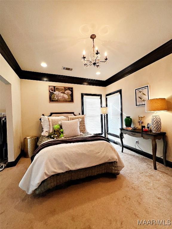 carpeted bedroom with crown molding and a chandelier