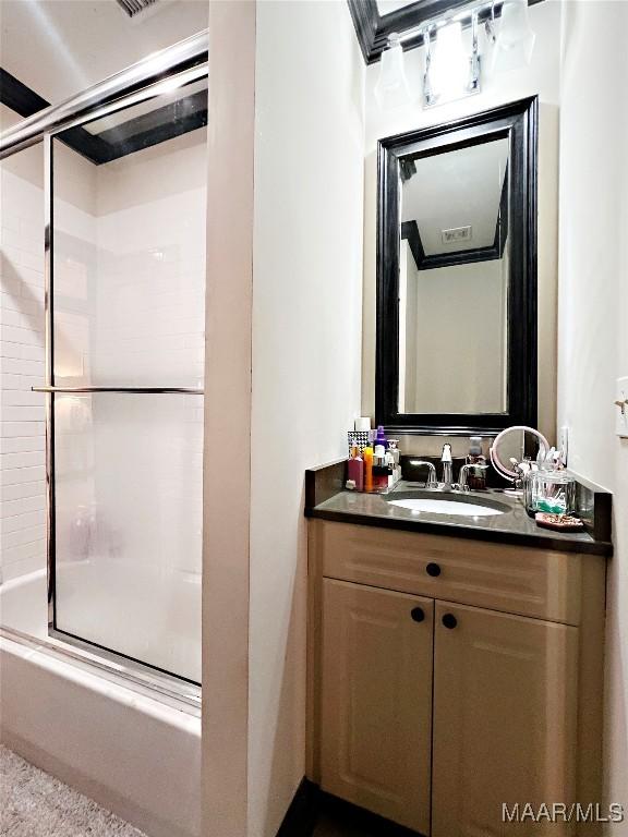 bathroom with vanity and bath / shower combo with glass door