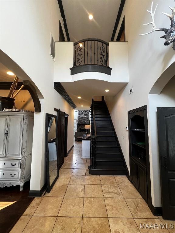 tiled entrance foyer with a towering ceiling and a barn door