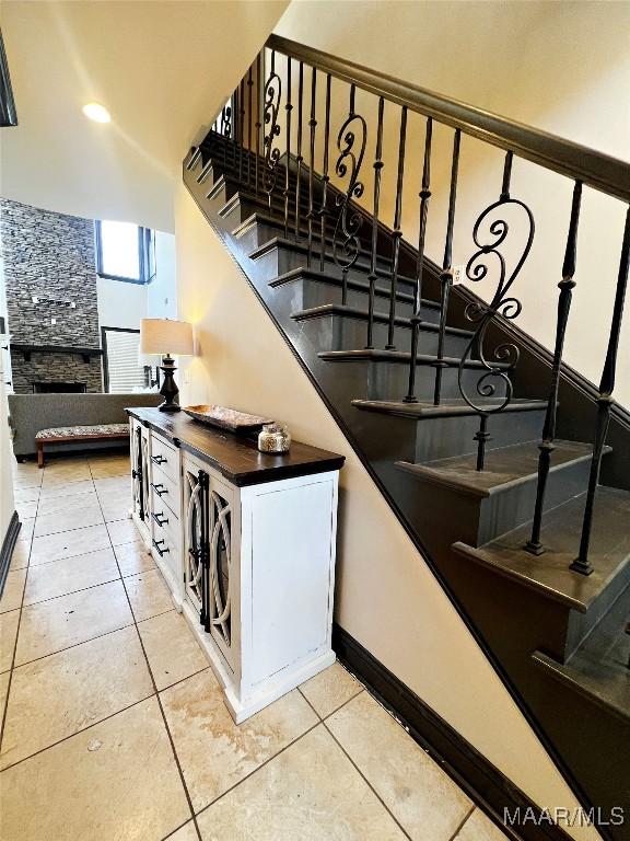 stairs featuring a fireplace and tile patterned floors