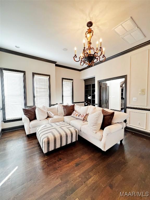 living room featuring crown molding, dark hardwood / wood-style floors, and a notable chandelier