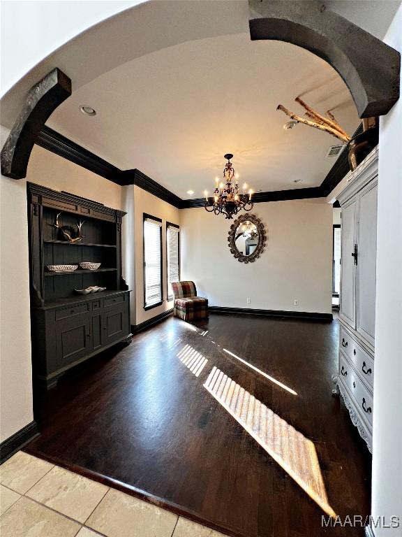 entryway featuring a notable chandelier, crown molding, wood-type flooring, and a baseboard radiator