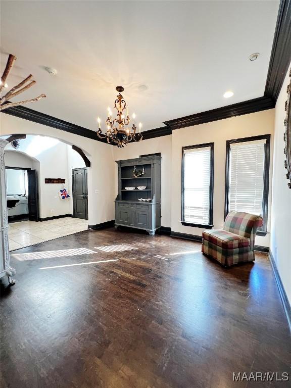 unfurnished living room featuring crown molding and a chandelier