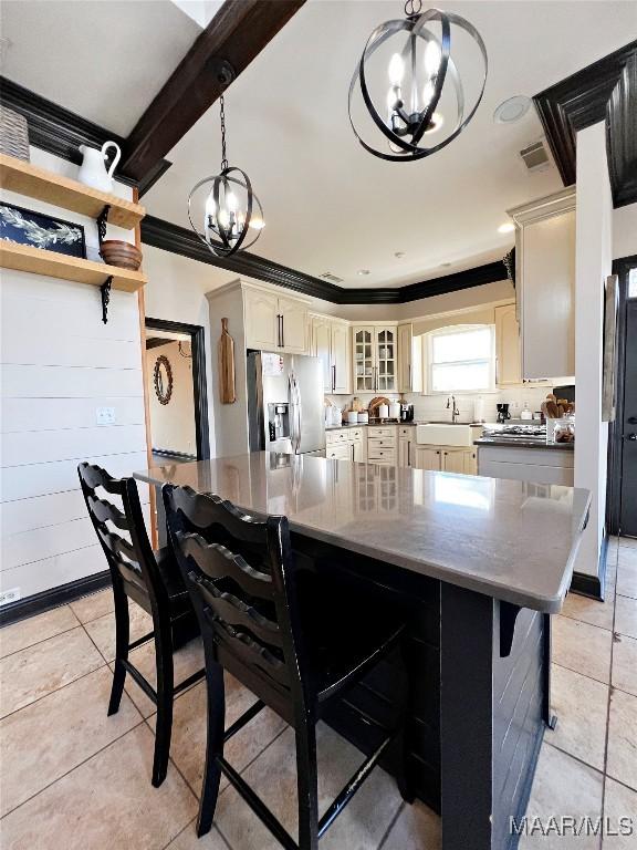 kitchen featuring ornamental molding, sink, an inviting chandelier, and stainless steel fridge with ice dispenser