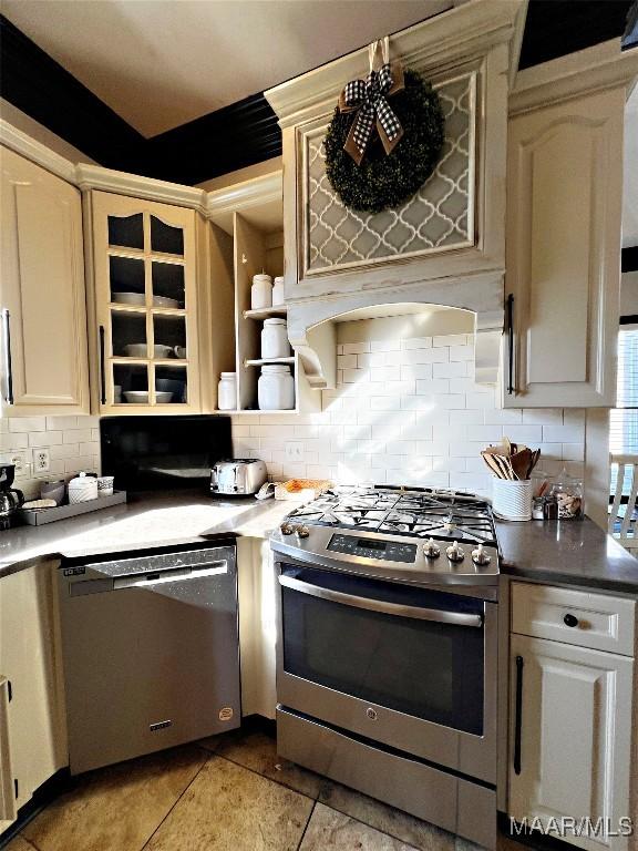 kitchen with stainless steel appliances, decorative backsplash, and cream cabinetry