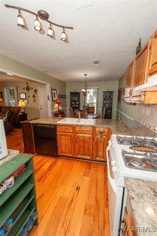 kitchen featuring sink, dishwasher, a notable chandelier, white gas range, and light wood-type flooring