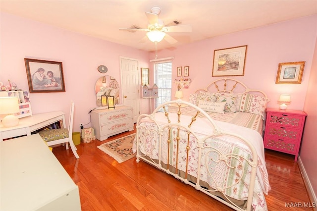 bedroom featuring hardwood / wood-style flooring, ceiling fan, and a closet