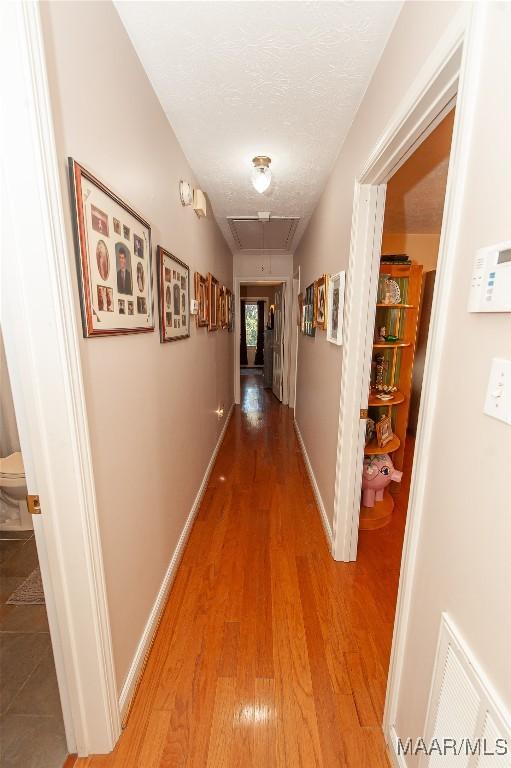 hallway featuring hardwood / wood-style floors and a textured ceiling