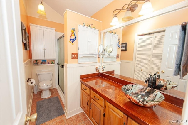 bathroom featuring tile patterned floors, toilet, a shower with shower door, and vanity