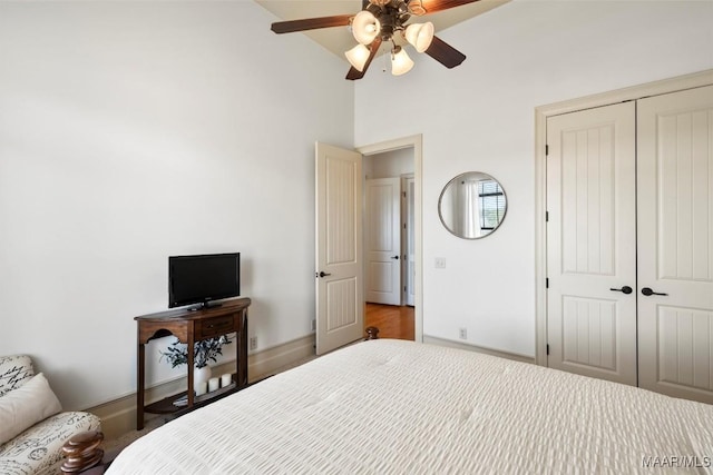 bedroom featuring a towering ceiling, ceiling fan, and a closet