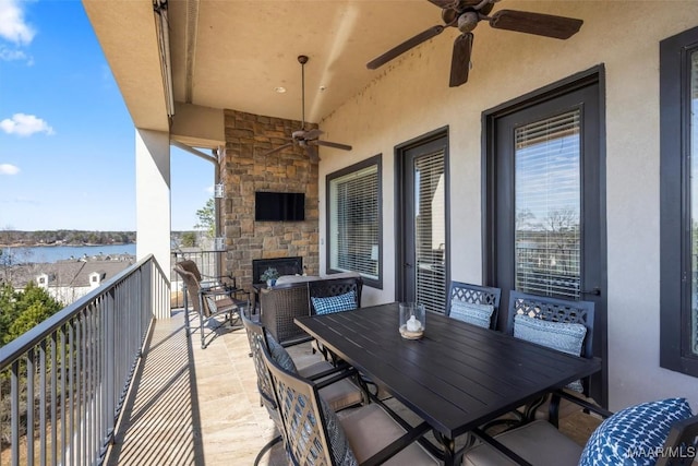 view of patio featuring ceiling fan, a balcony, and an outdoor stone fireplace