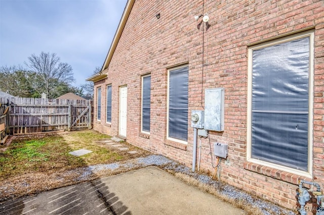 view of home's exterior featuring fence and brick siding