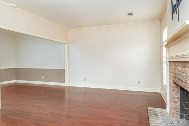 unfurnished living room with baseboards, a brick fireplace, wood finished floors, and crown molding