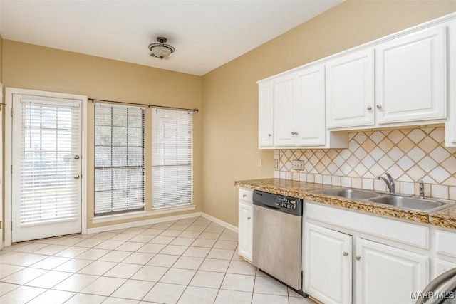 kitchen featuring light tile patterned floors, tasteful backsplash, stainless steel dishwasher, white cabinetry, and a sink