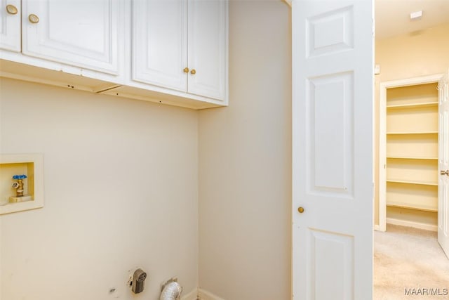 clothes washing area featuring hookup for a washing machine, light colored carpet, cabinet space, and baseboards