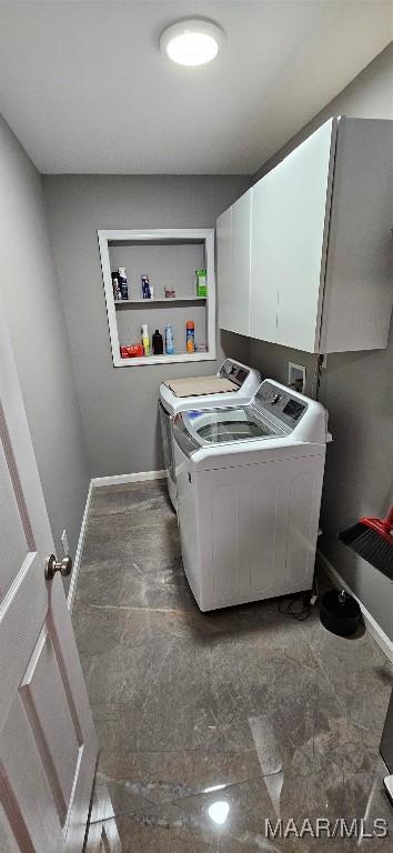 washroom featuring washing machine and dryer and cabinets