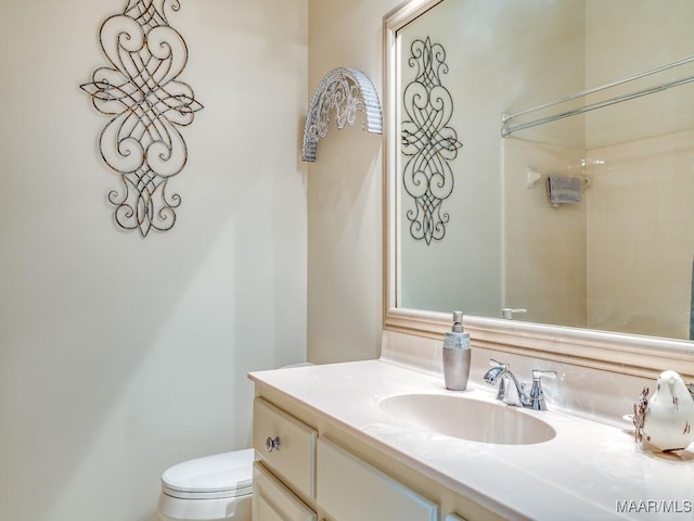 bathroom featuring vanity, a shower, and toilet