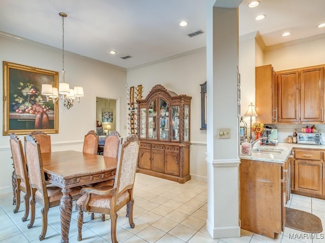 dining room featuring light tile patterned flooring, ornamental molding, sink, and a notable chandelier