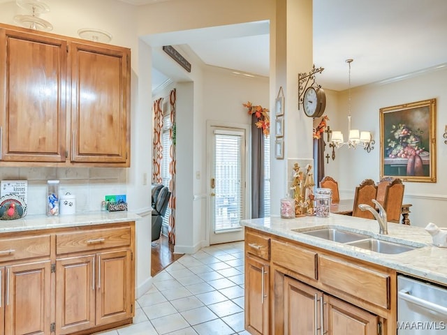 kitchen featuring pendant lighting, sink, light stone counters, light tile patterned flooring, and a chandelier