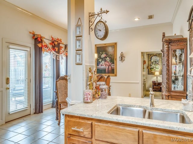 kitchen featuring crown molding, light stone countertops, sink, and light tile patterned flooring