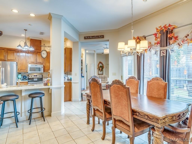 dining space featuring sink, ceiling fan with notable chandelier, ornamental molding, and light tile patterned flooring