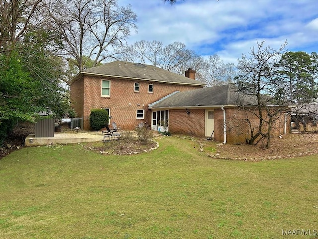 rear view of property with a patio and a lawn