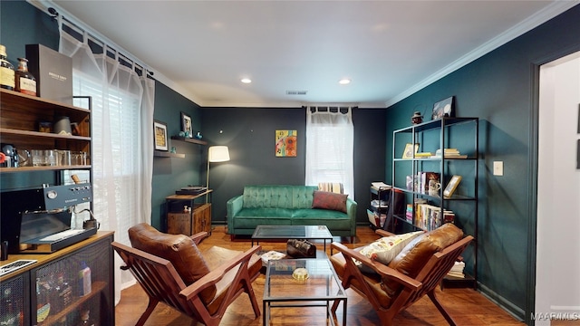 living area featuring hardwood / wood-style flooring and ornamental molding