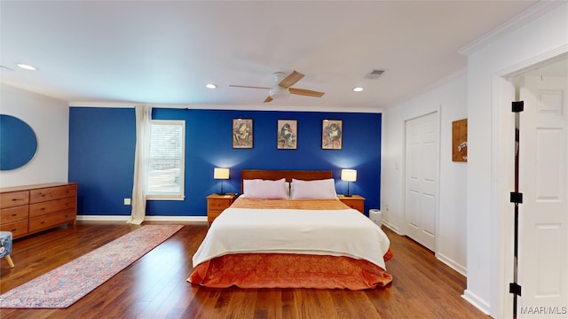 bedroom featuring dark hardwood / wood-style flooring, ornamental molding, and ceiling fan