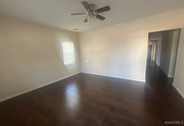 empty room featuring ceiling fan and dark hardwood / wood-style flooring