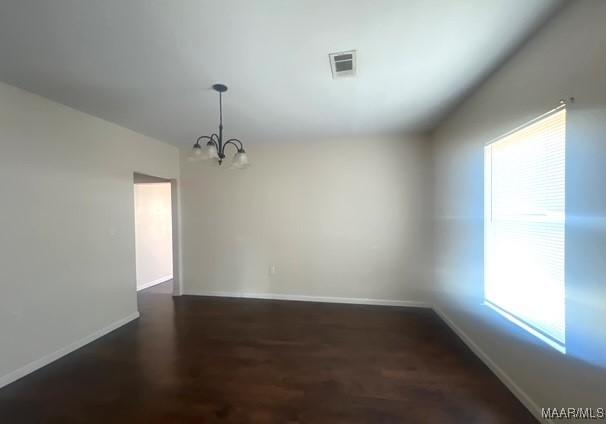 unfurnished dining area featuring dark hardwood / wood-style floors and a notable chandelier