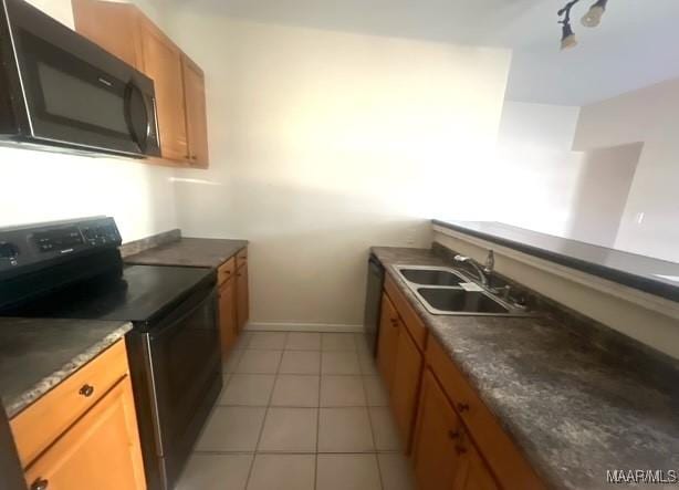 kitchen featuring sink, light tile patterned floors, and black / electric stove