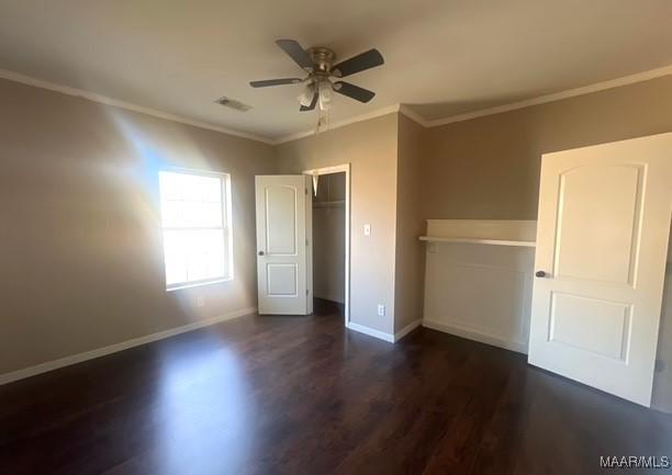 unfurnished bedroom featuring a closet, crown molding, dark hardwood / wood-style floors, and ceiling fan