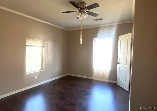 spare room with ornamental molding, dark wood-type flooring, and ceiling fan