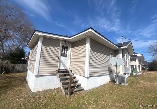 view of property exterior featuring cooling unit and a lawn