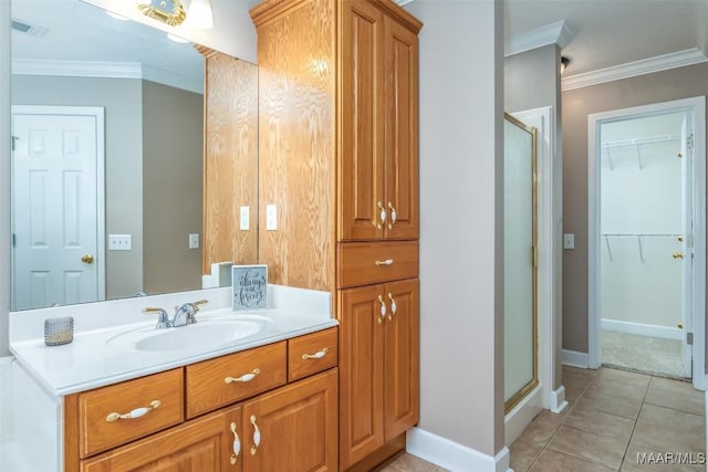 bathroom featuring tile patterned flooring, vanity, ornamental molding, and walk in shower