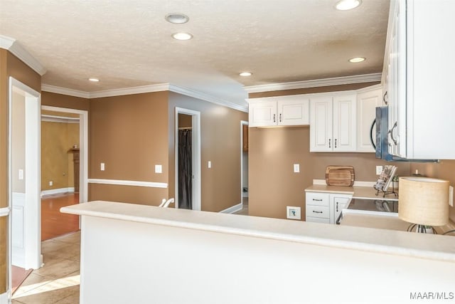 kitchen featuring white cabinets, light tile patterned floors, kitchen peninsula, crown molding, and a textured ceiling