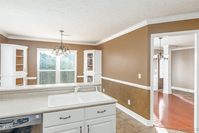 kitchen featuring an inviting chandelier, white cabinetry, black dishwasher, and sink