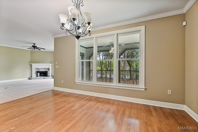 unfurnished living room featuring crown molding, ceiling fan with notable chandelier, a high end fireplace, and light hardwood / wood-style flooring