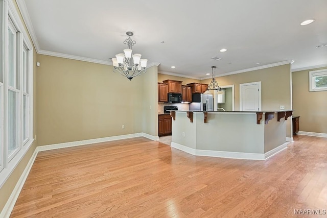 kitchen featuring a breakfast bar, decorative light fixtures, a chandelier, light wood-type flooring, and stainless steel fridge