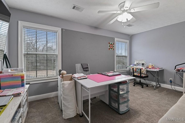 carpeted office featuring a textured ceiling and ceiling fan