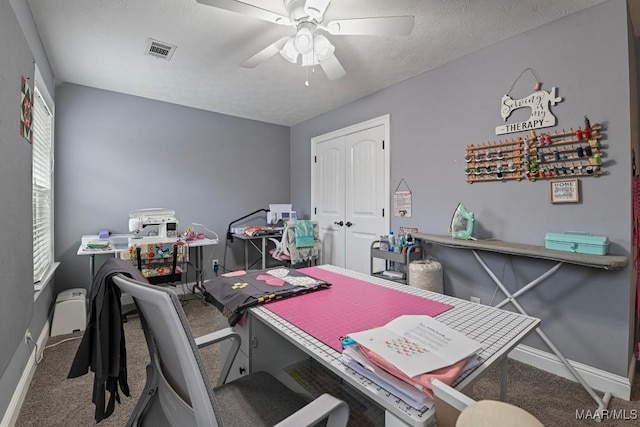 carpeted office space featuring a textured ceiling and ceiling fan