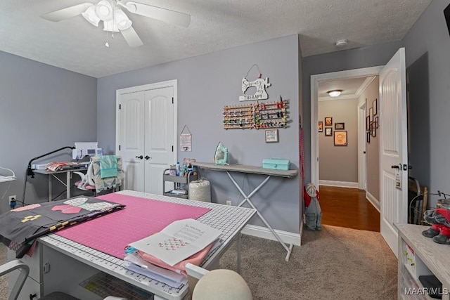 office area featuring ceiling fan, carpet flooring, and a textured ceiling