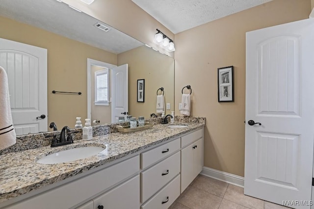 bathroom with vanity, tile patterned flooring, and a textured ceiling