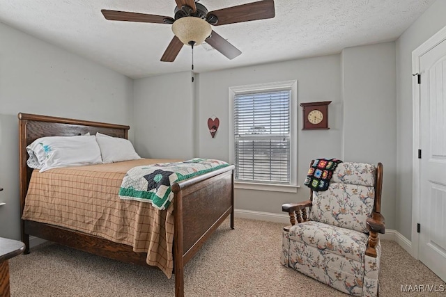 carpeted bedroom with ceiling fan and a textured ceiling