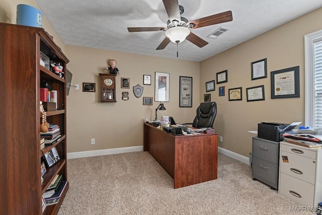 office featuring ceiling fan, light carpet, and a textured ceiling