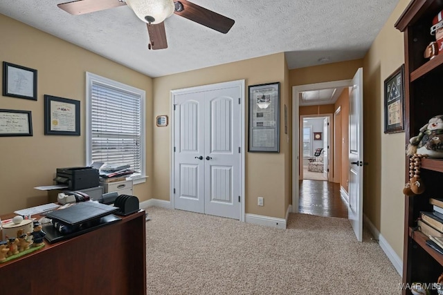 office area with a textured ceiling, ceiling fan, and carpet