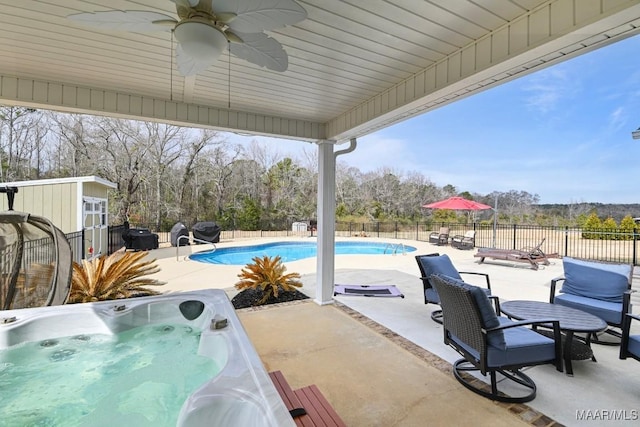 view of swimming pool featuring ceiling fan, a jacuzzi, and a patio area