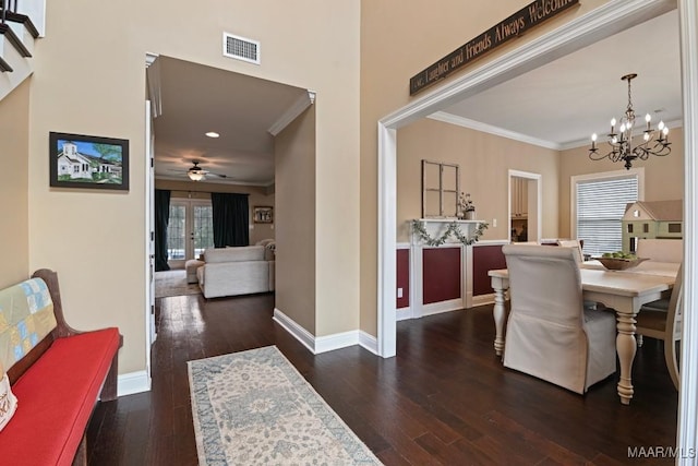 hallway featuring dark wood-type flooring, ornamental molding, and a chandelier