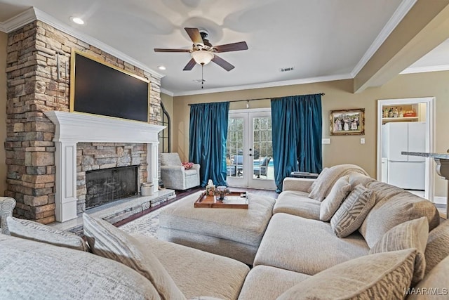 living room featuring crown molding, ceiling fan, a fireplace, and french doors